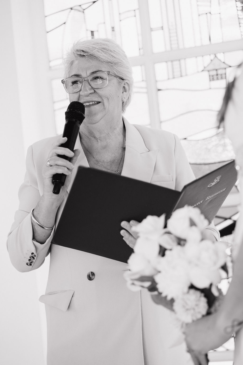 April Daley-Holmes, Gold Coast civil celebrant, speaking at a ceremony with microphone and register
