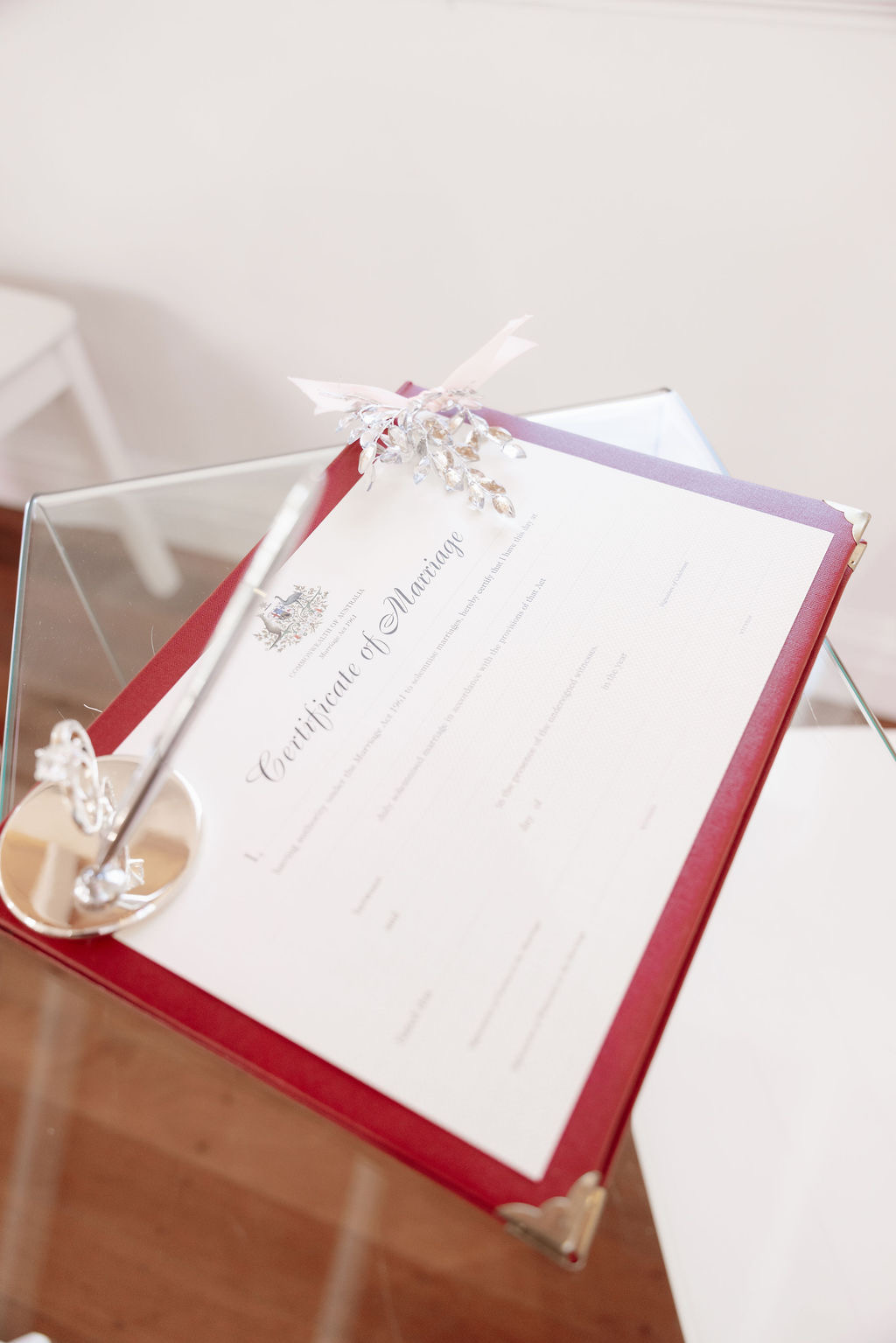 Official Certificate of Marriage in a red presentation folder with pen and ring dish