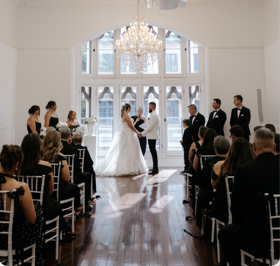 Elegant wedding ceremony in a bright white chapel with crystal chandelier
